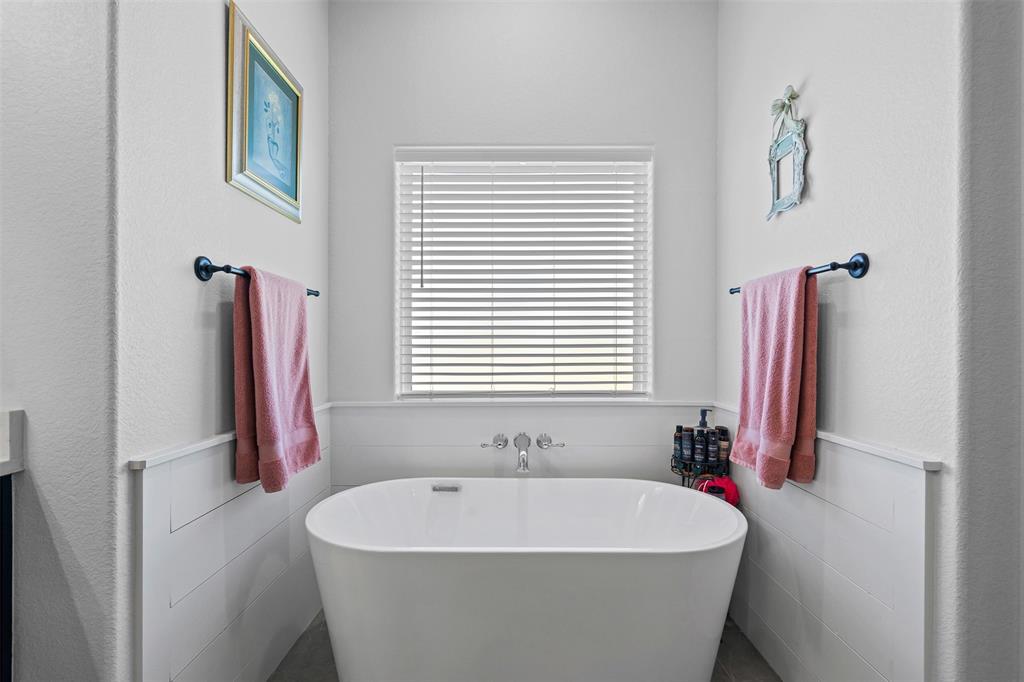 2045 Ellis Ridge Drive Weatherford, TX 76087 - Photo 18 of 40 Bathroom with a soaking tub, vanity, a textured wall, and a wainscoted wall