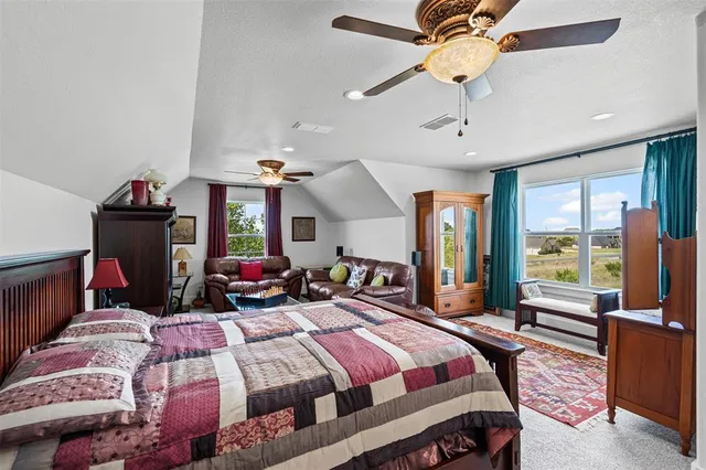 a bedroom with a bed ceiling fan and a window