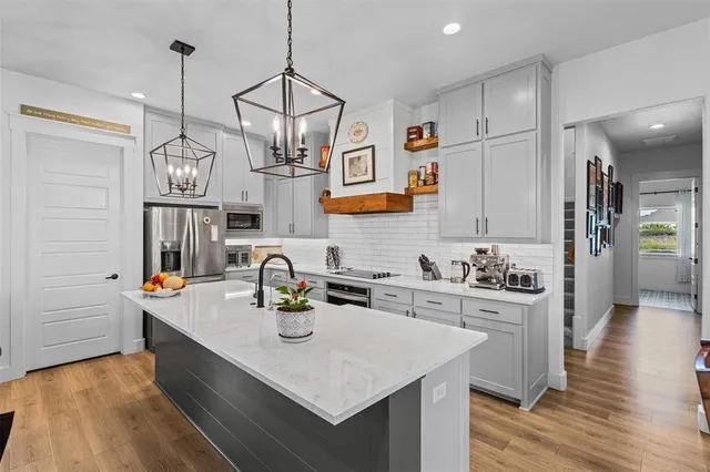 a kitchen with stainless steel appliances a sink stove and refrigerator