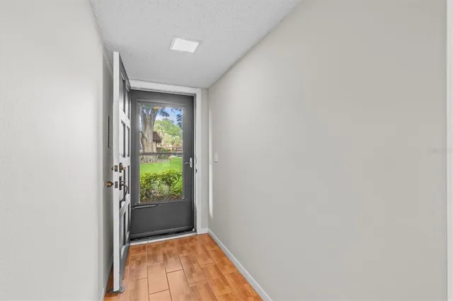 a view of a hallway with wooden floor and a window