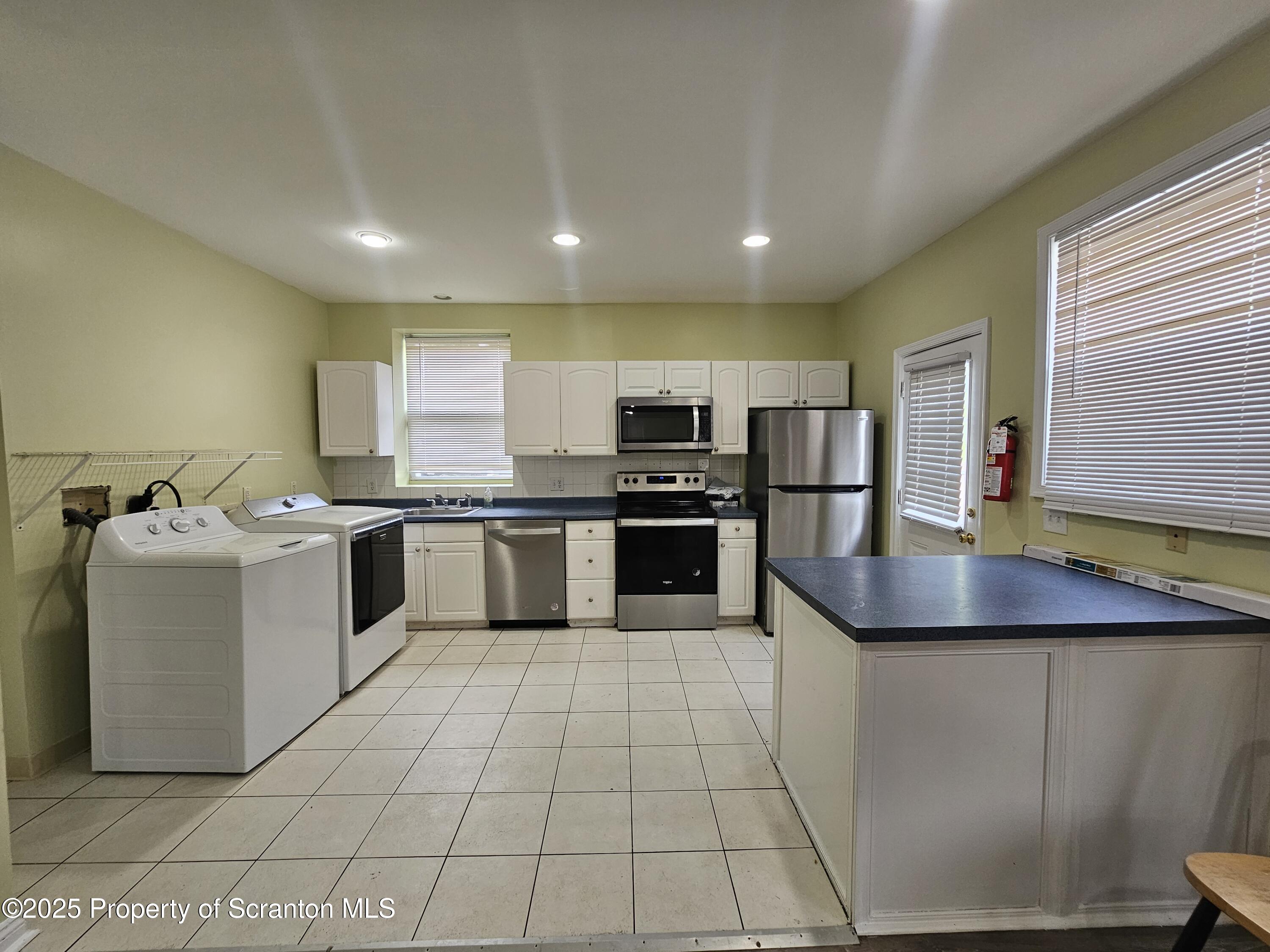 1207 Mulberry Street Scranton, PA 18510 - Photo 3 of 21 a kitchen with stainless steel appliances granite countertop a sink counter space cabinets and a large window