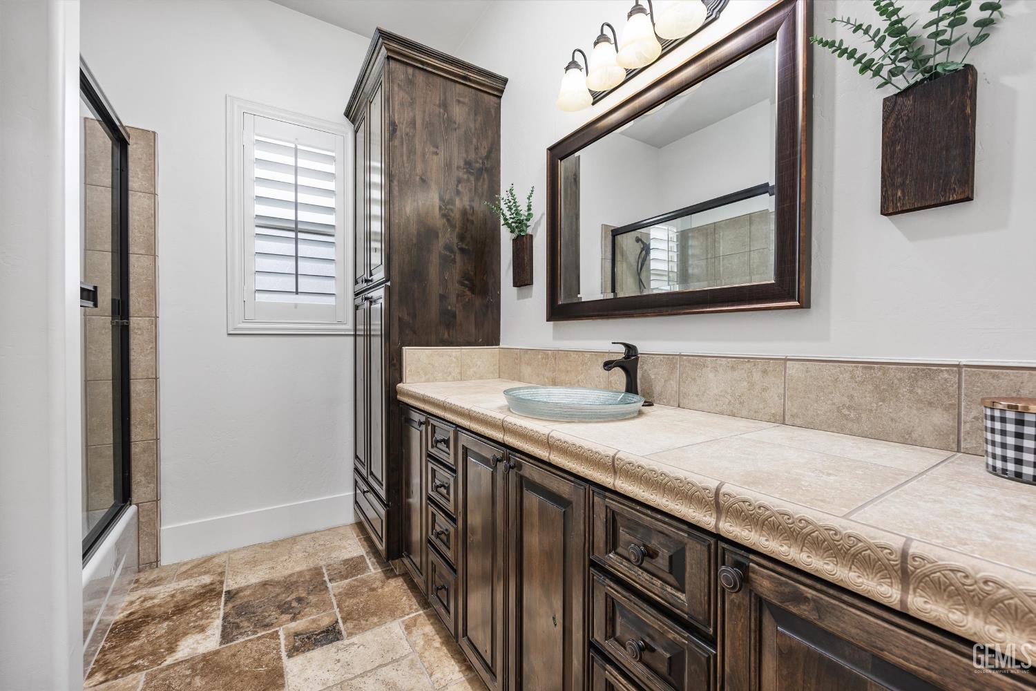 Undisclosed Address Bakersfield, CA 93314 - Photo 29 of 59 a bathroom with a granite countertop sink a mirror and shower