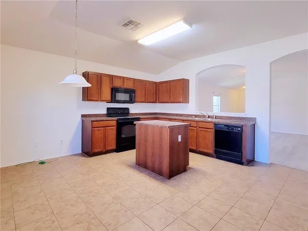 a kitchen with stainless steel appliances granite countertop a stove a sink and a refrigerator