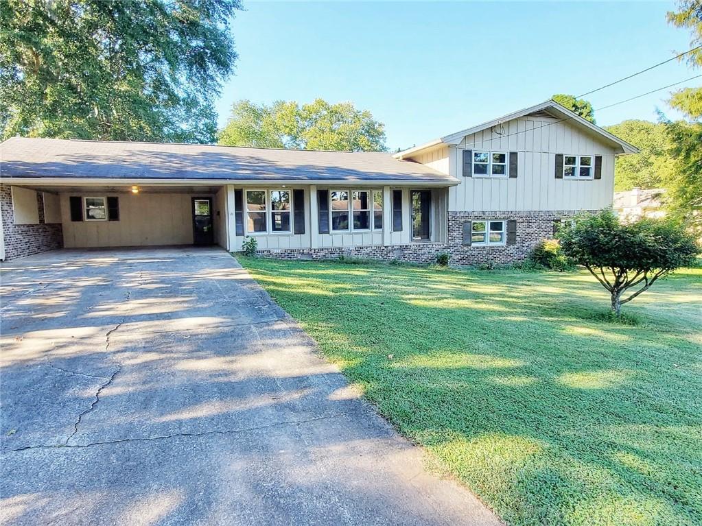a view of a house with a yard and sitting area