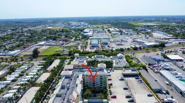 a view of a dining room and livingroom with furniture wooden floor a rug a fireplace and a chandelier