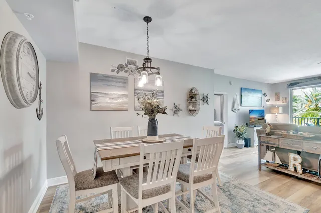 a living room with furniture potted plant floor to ceiling windows and a flat screen tv