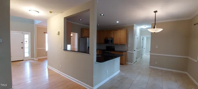 a view of a hallway with wooden floor windows and a living room