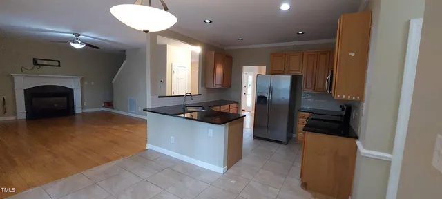 a kitchen with stainless steel appliances granite countertop a refrigerator a stove and a sink