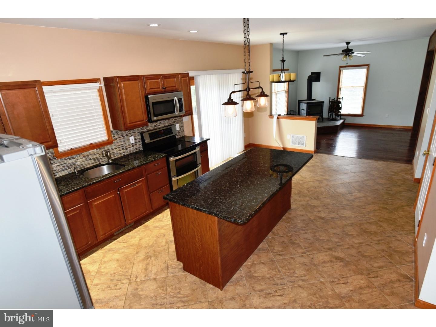 529 Province Line Road Allentown, NJ 08501 - Photo 3 of 21 a kitchen with stainless steel appliances granite countertop a stove top oven a sink dishwasher and microwave with wooden floor