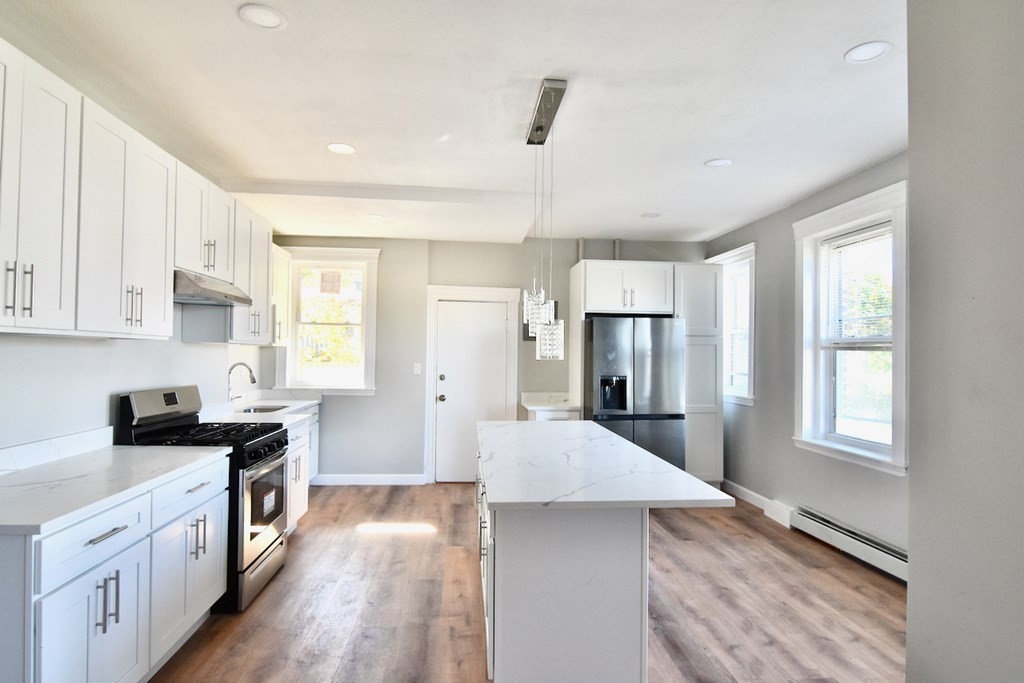 a kitchen with a refrigerator and windows