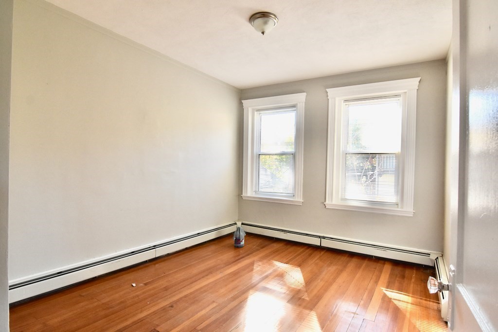 103 Homestead Street, Unit 1 Boston, MA 02121 - Photo 12 of 16 an empty room with wooden floor and windows