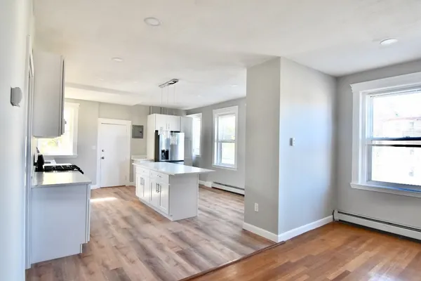 a kitchen view with wooden floor and a window
