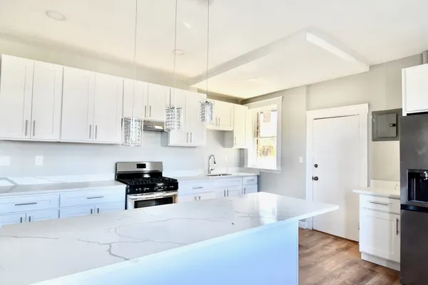 a kitchen with white cabinets and stainless steel appliances