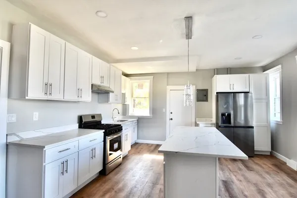 a kitchen with white cabinets and stainless steel appliances