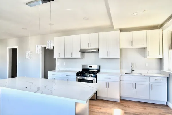 a kitchen with white cabinets and stainless steel appliances