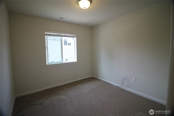an empty room that has a wooden cupboard