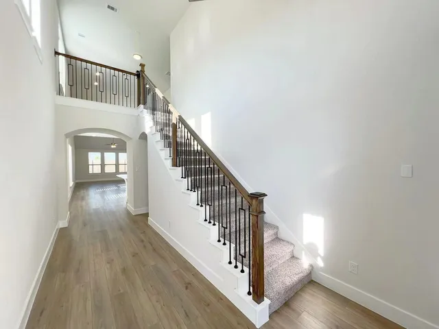 a view of staircase with wooden floor and white walls