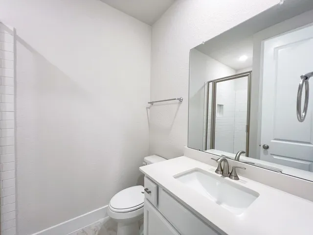 a bathroom with a sink a toilet and a mirror