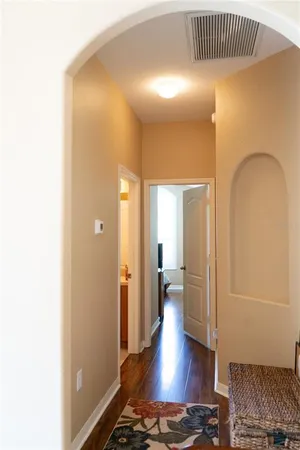 a room with painting on the wall and a dresser