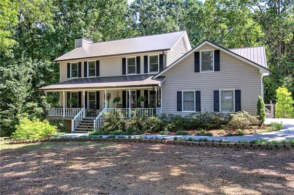 a front view of a house with a yard and potted plants