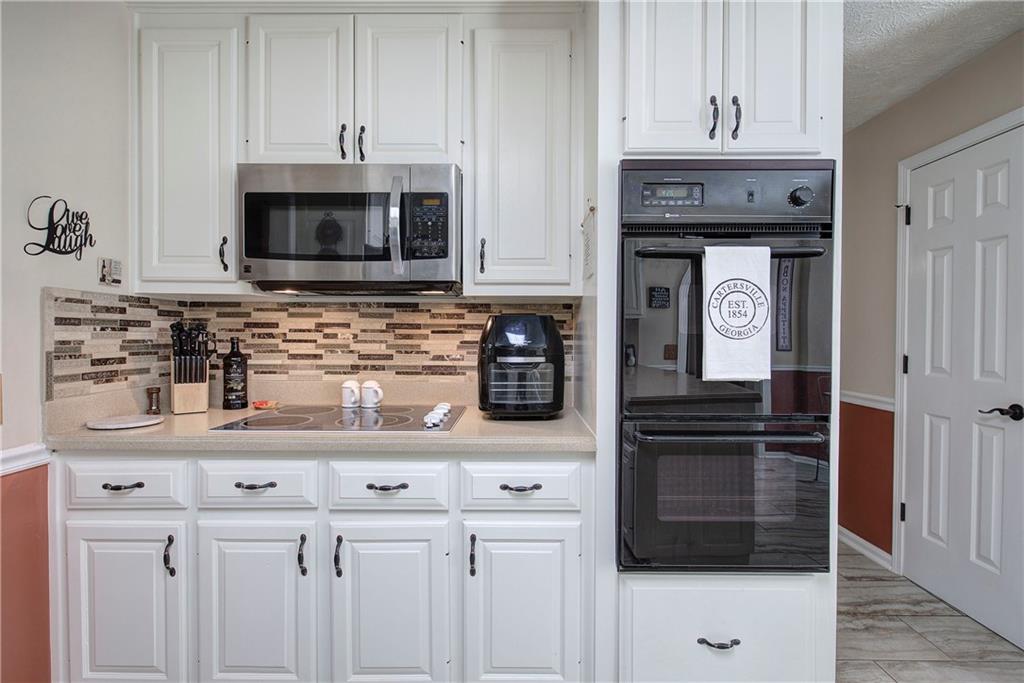 338 East Valley Road Northeast Rydal, GA 30171 - Photo 12 of 53 a kitchen with granite countertop white cabinets and stainless steel appliances