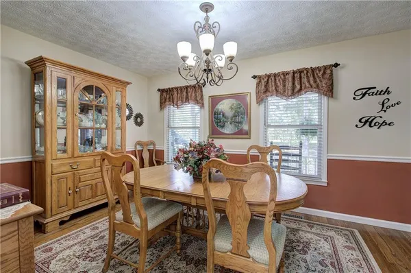 a view of a dining room with furniture a chandelier and wooden floor