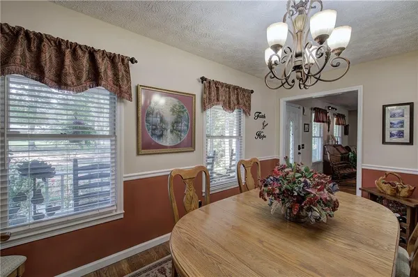 a view of a dining room with furniture and chandelier