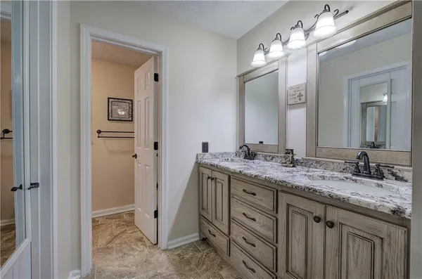 a bathroom with a granite countertop sink vanity and a mirror