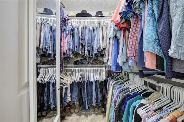 a view of walk in closet with clothes