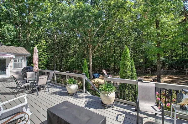 a view of a patio with table and chairs potted plants with wooden floor and fence