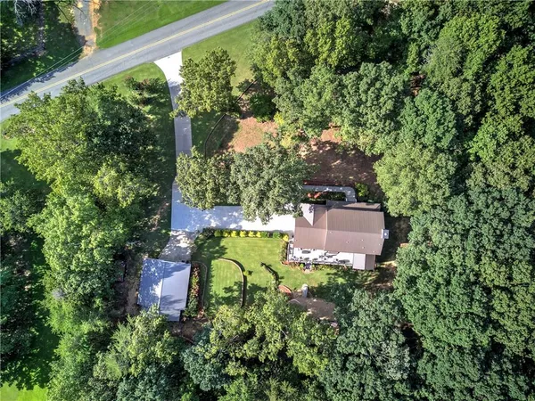 an aerial view of a house with a yard wooden fence and a bench