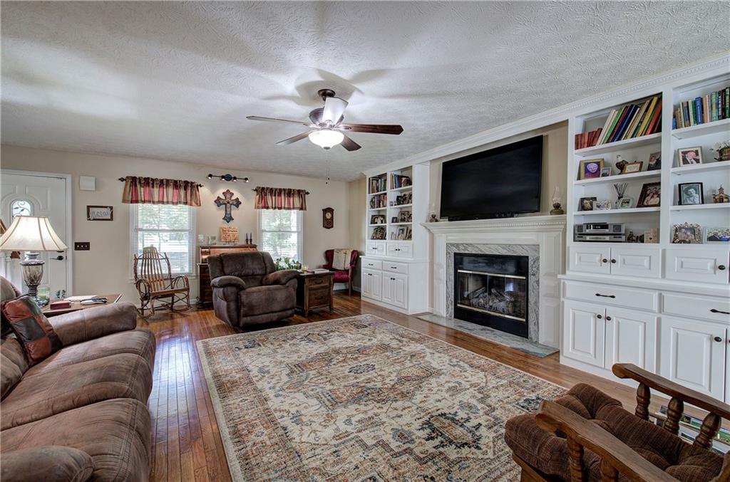 338 East Valley Road Northeast Rydal, GA 30171 - Photo 7 of 53 a living room with furniture a flat screen tv and a fireplace