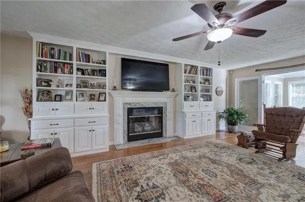 a living room with furniture a flat screen tv and a fireplace