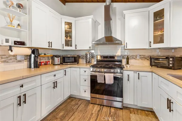 a kitchen with stainless steel appliances granite countertop a stove and white cabinets