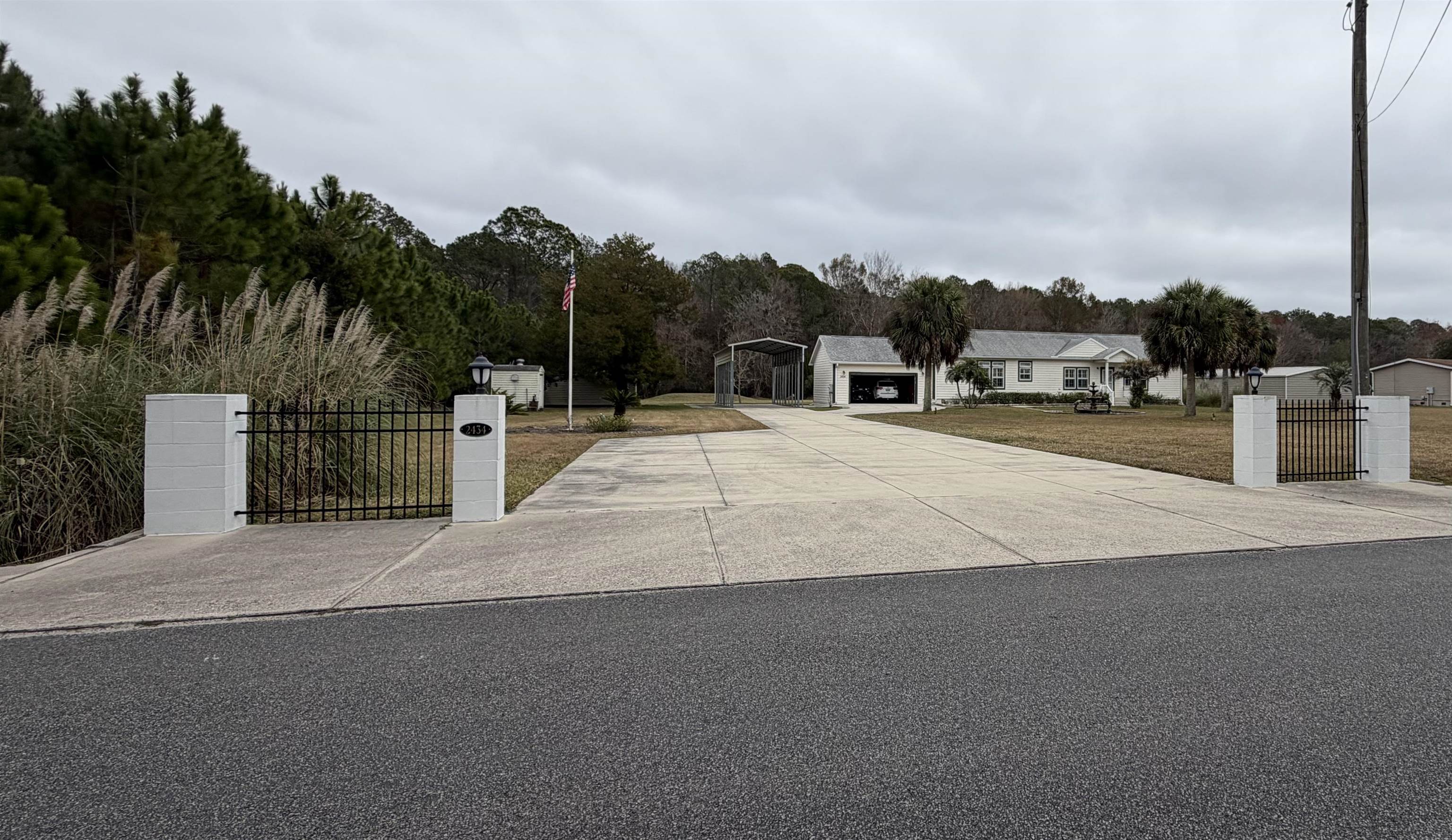 View of concrete driveway featuring a gate