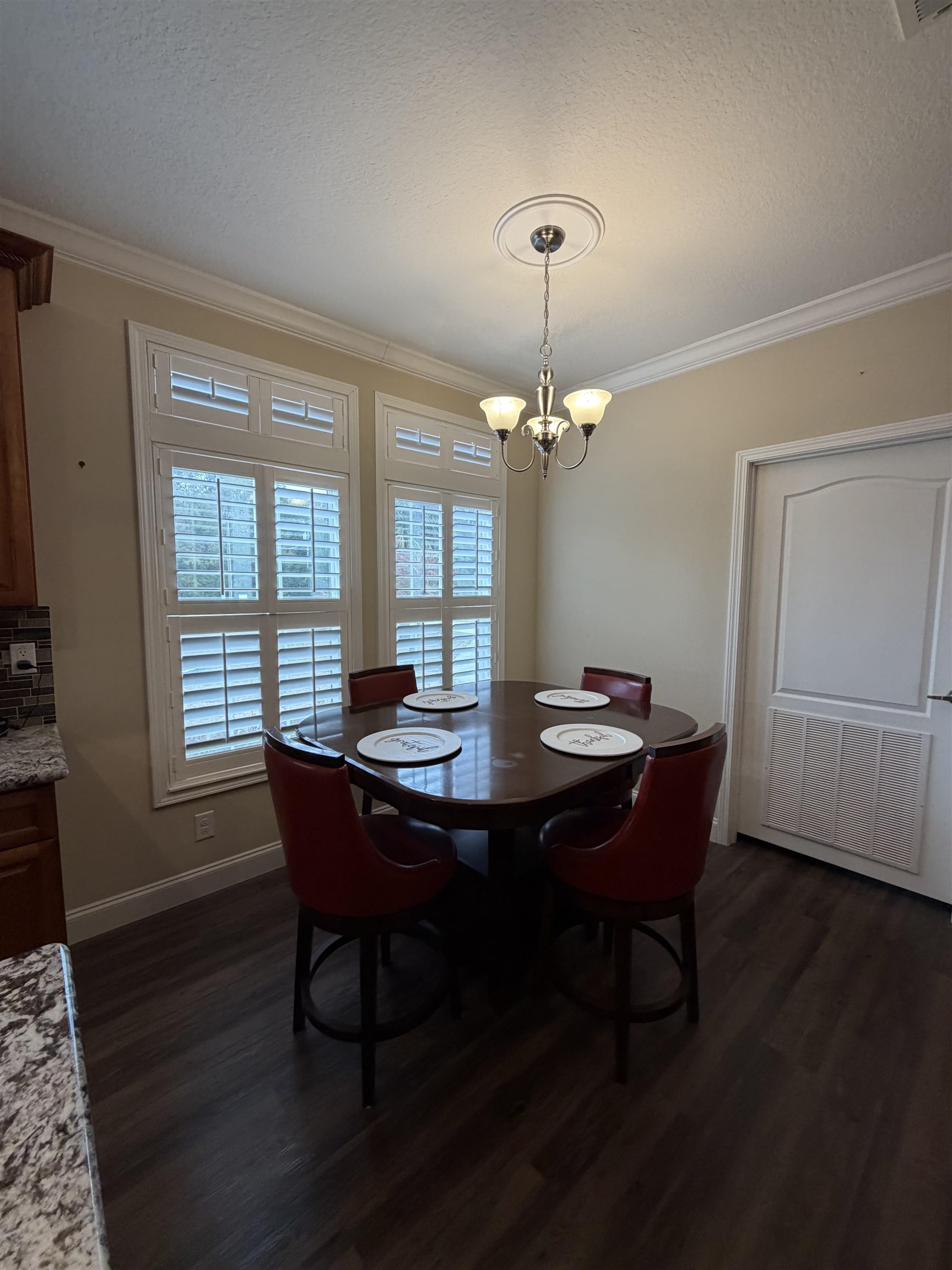 2434 Pellicer Road St. Augustine, FL 32092 - Photo 12 of 41 Dining space with a textured ceiling, dark wood-style floors, ornamental molding, and a chandelier