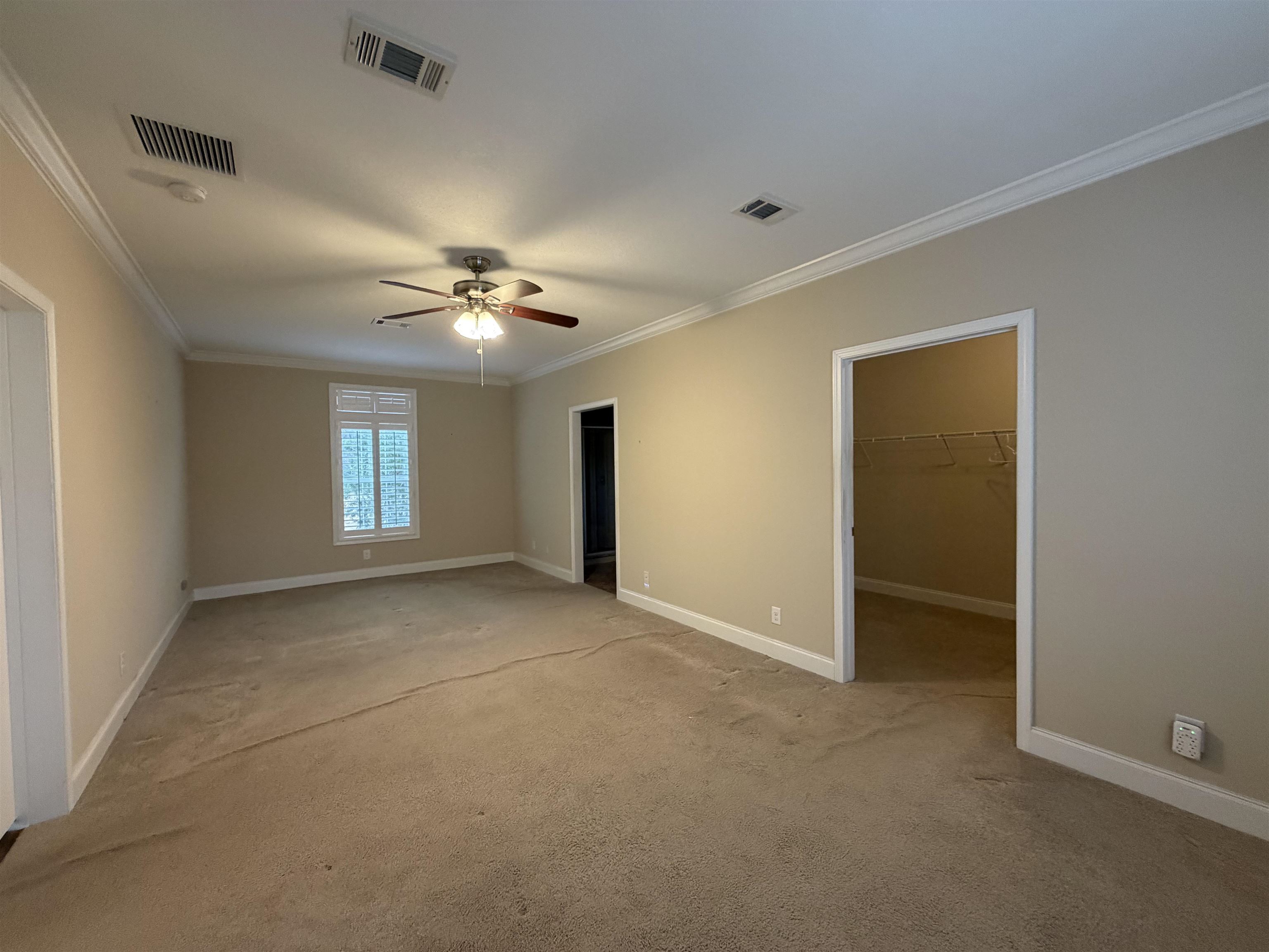 2434 Pellicer Road St. Augustine, FL 32092 - Photo 23 of 41 Unfurnished bedroom with a walk in closet, light carpet, crown molding, and ceiling fan