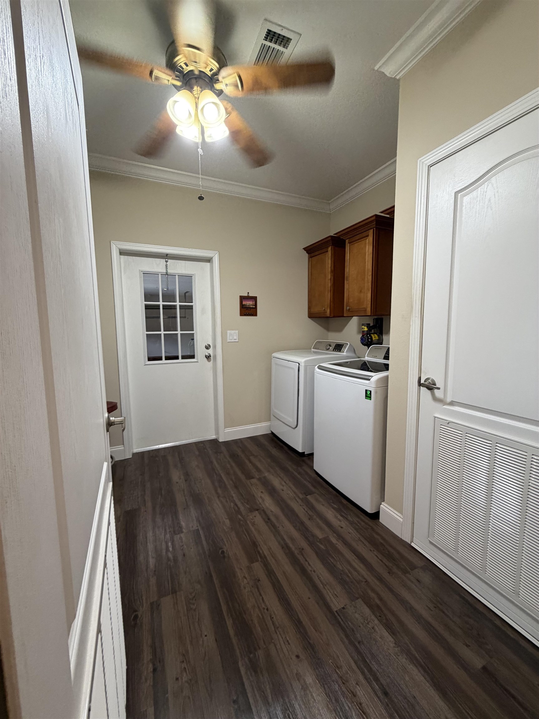 2434 Pellicer Road St. Augustine, FL 32092 - Photo 34 of 41 Laundry room featuring crown molding, cabinet space, dark wood-style flooring, separate washer and dryer, and a ceiling fan