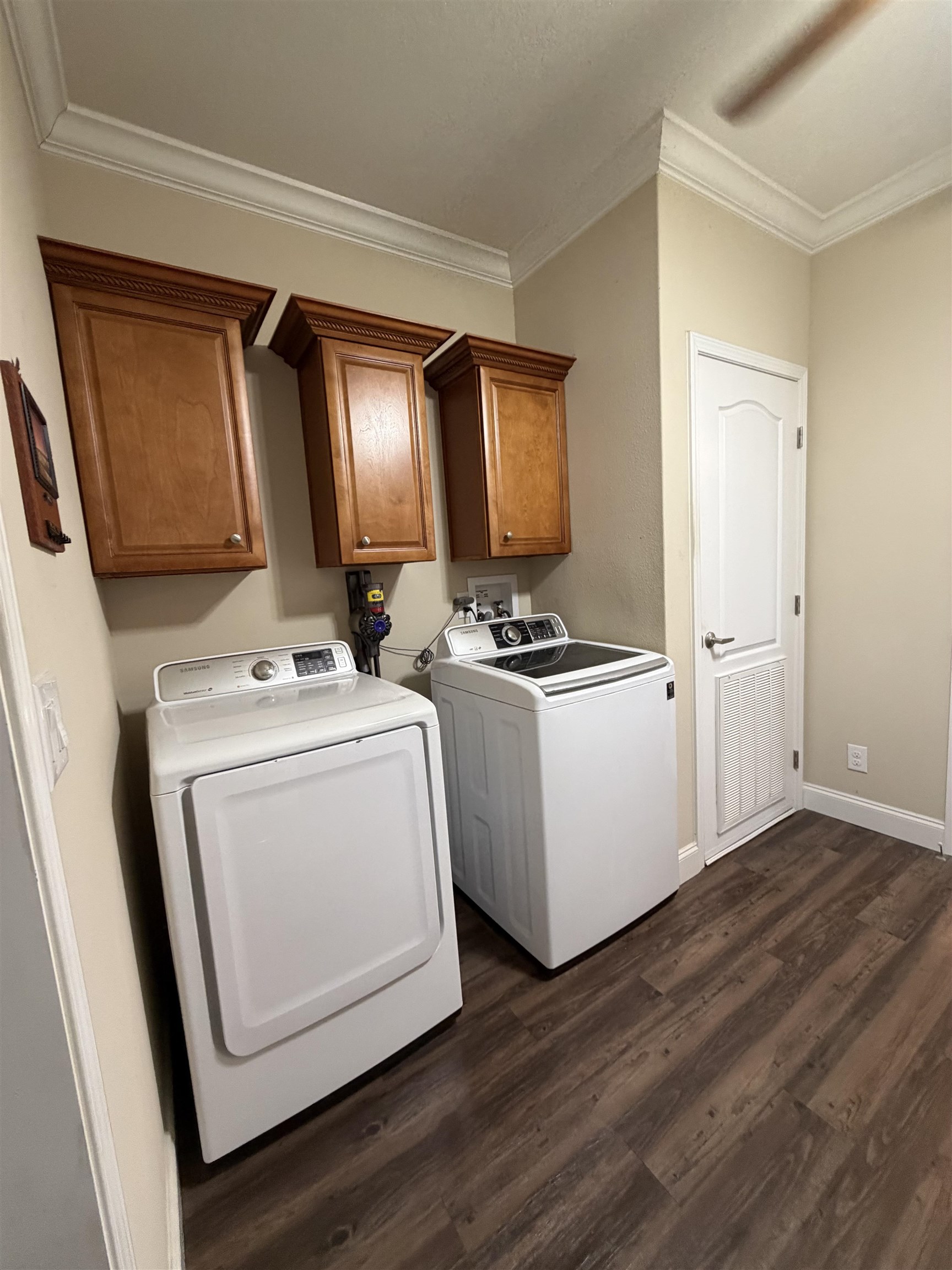 2434 Pellicer Road St. Augustine, FL 32092 - Photo 35 of 41 Laundry room featuring dark wood finished floors, independent washer and dryer, crown molding, and cabinet space