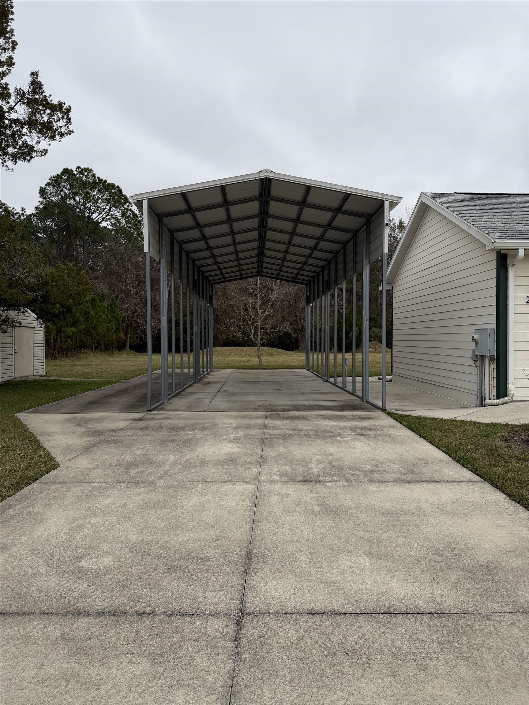 2434 Pellicer Road St. Augustine, FL 32092 - Photo 36 of 41 View of parking featuring driveway, a detached carport, and a storage unit
