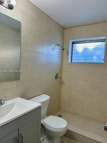 a white toilet sitting next to a shower