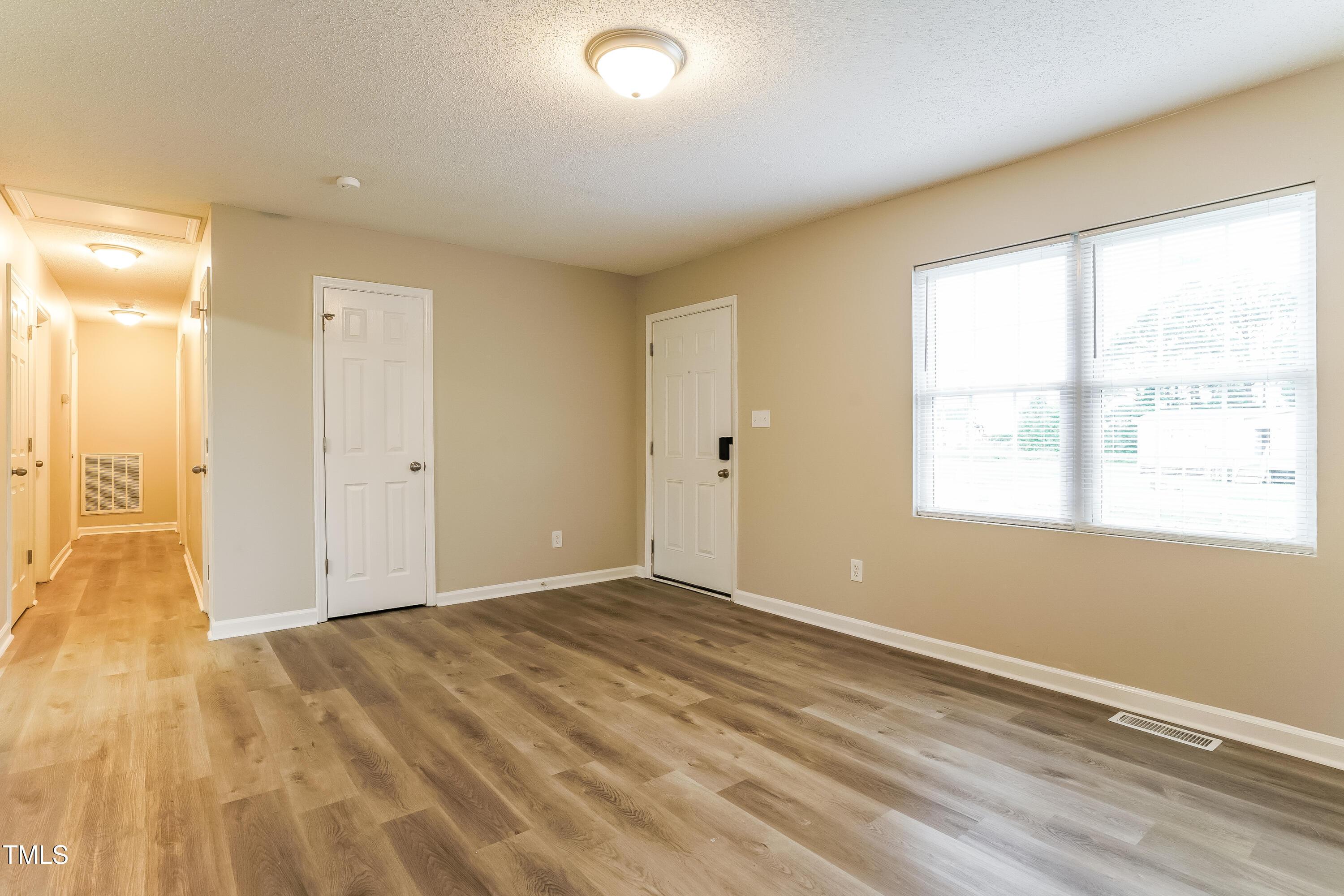 939 Rand Street Smithfield, NC 27577 - Photo 3 of 16 a view of empty room with wooden floor and fan
