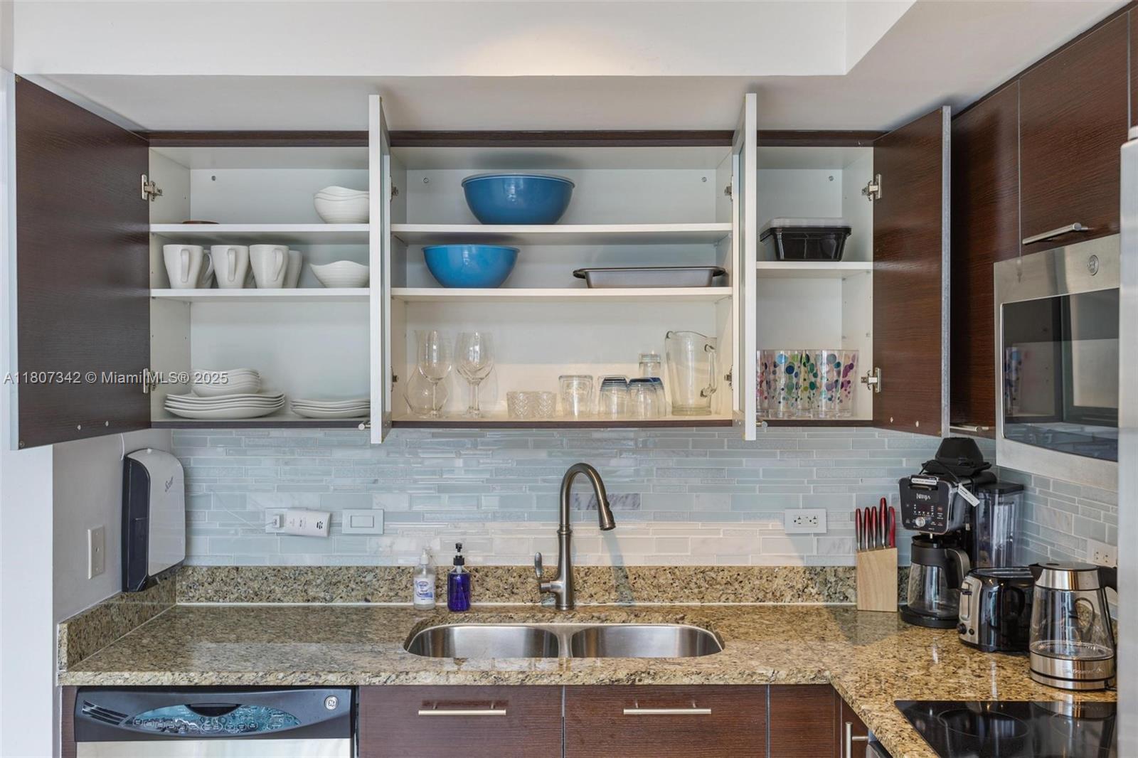 41 Southeast 5th Street, Unit 2008 Miami, FL 33131 - Photo 17 of 54 a kitchen with granite countertop a sink a stove and a wooden cabinets