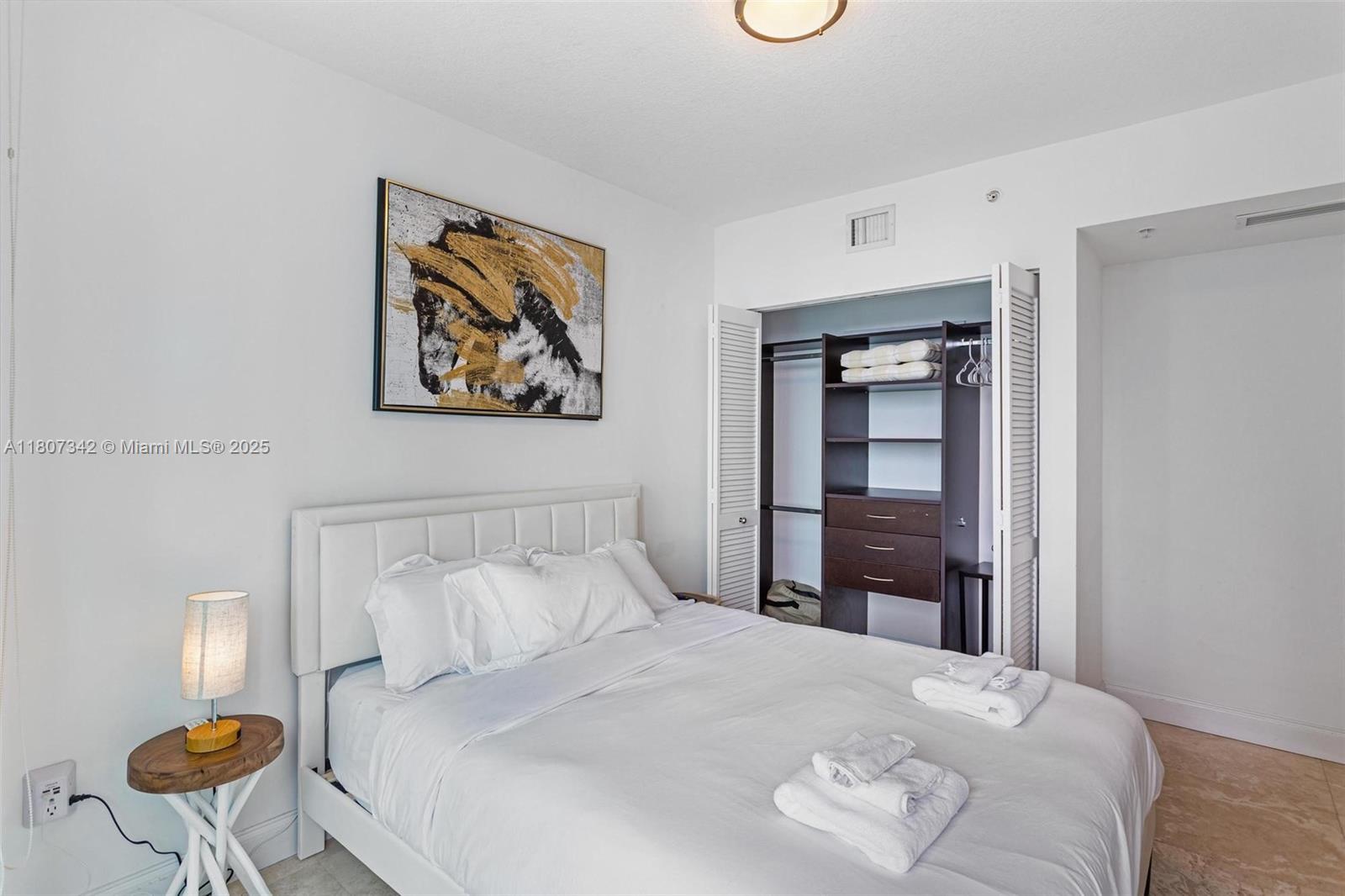 41 Southeast 5th Street, Unit 2008 Miami, FL 33131 - Photo 21 of 54 a bedroom with a bed and a painting on the wall