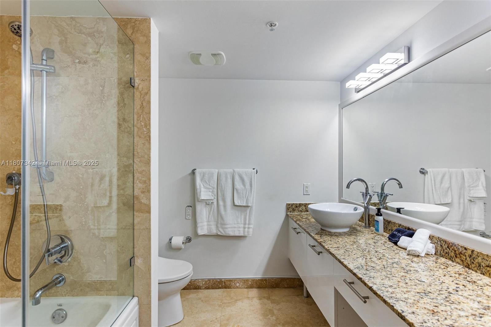 41 Southeast 5th Street, Unit 2008 Miami, FL 33131 - Photo 34 of 54 a bathroom with a granite countertop sink a toilet and shower