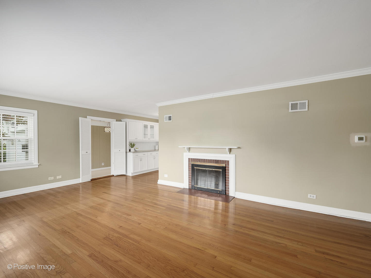 337 Wagner Road Northfield, IL 60093 - Photo 3 of 22 an empty room with wooden floor a fireplace and windows