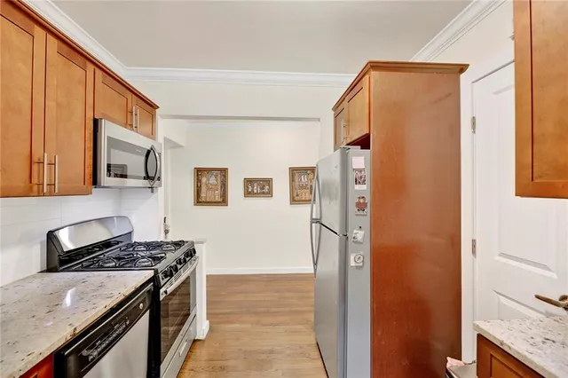 a kitchen with stainless steel appliances granite countertop a refrigerator and a stove top oven
