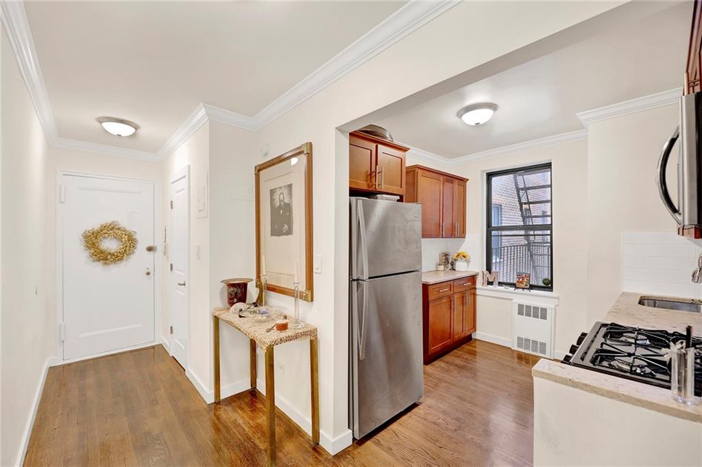 40 89th Street, Unit 4F Brooklyn, NY 11209 - Photo 7 of 22 a kitchen with stainless steel appliances a refrigerator a stove a sink and a wooden floors