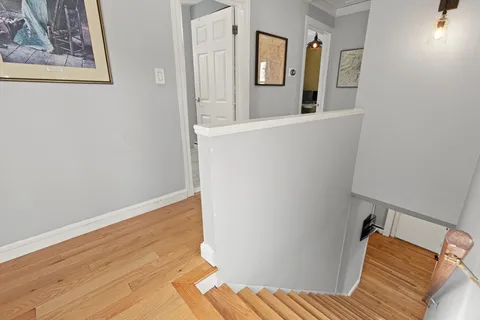 a view of a bedroom with wooden floor and hallway