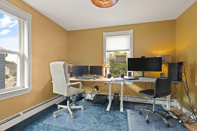 a view of a workspace with furniture and a window